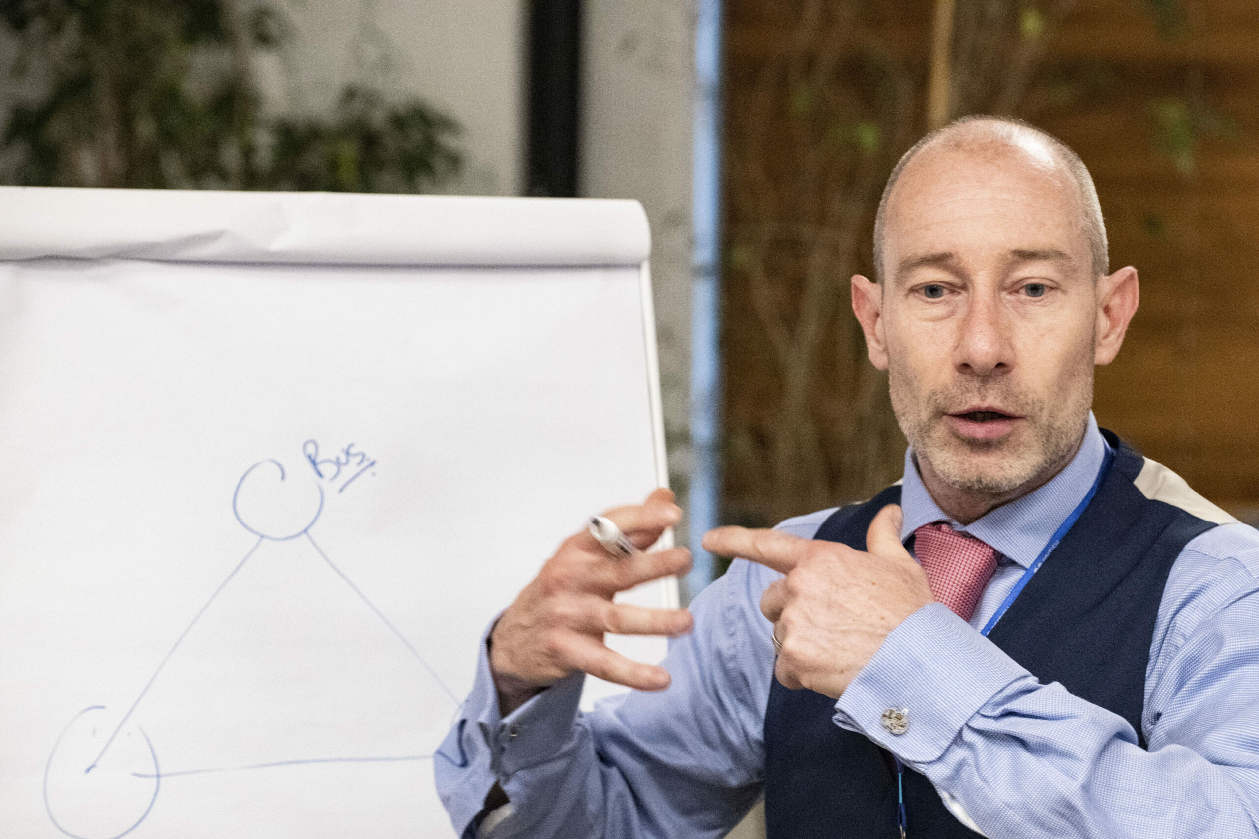 John Holmes of Advantage Creative explaining business coaching in front of a white flipchart.